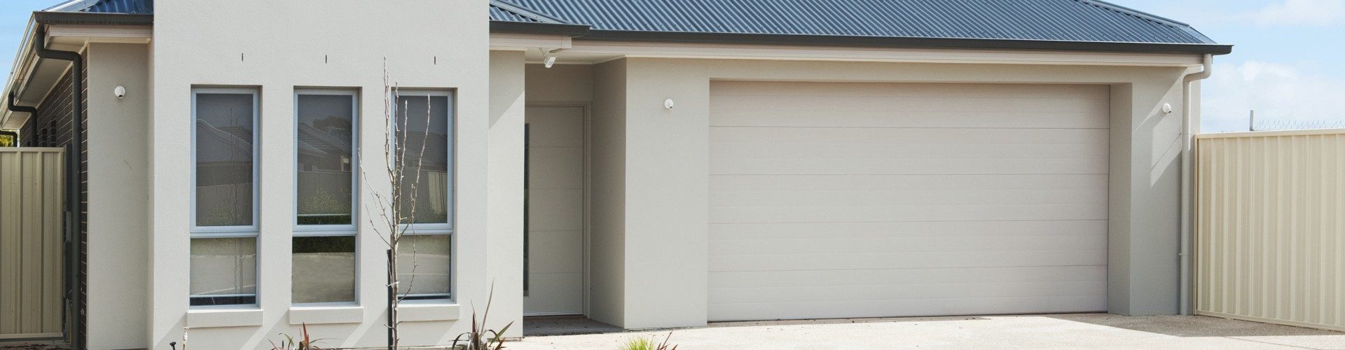 Stock photograph of a plaster-clad house with a double garage, of the monolithic-cladding type associated with leaky building syndrome